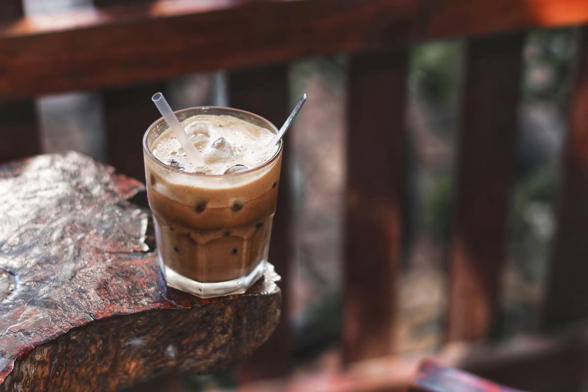 Iced coffee with swirling milk in a tall glass